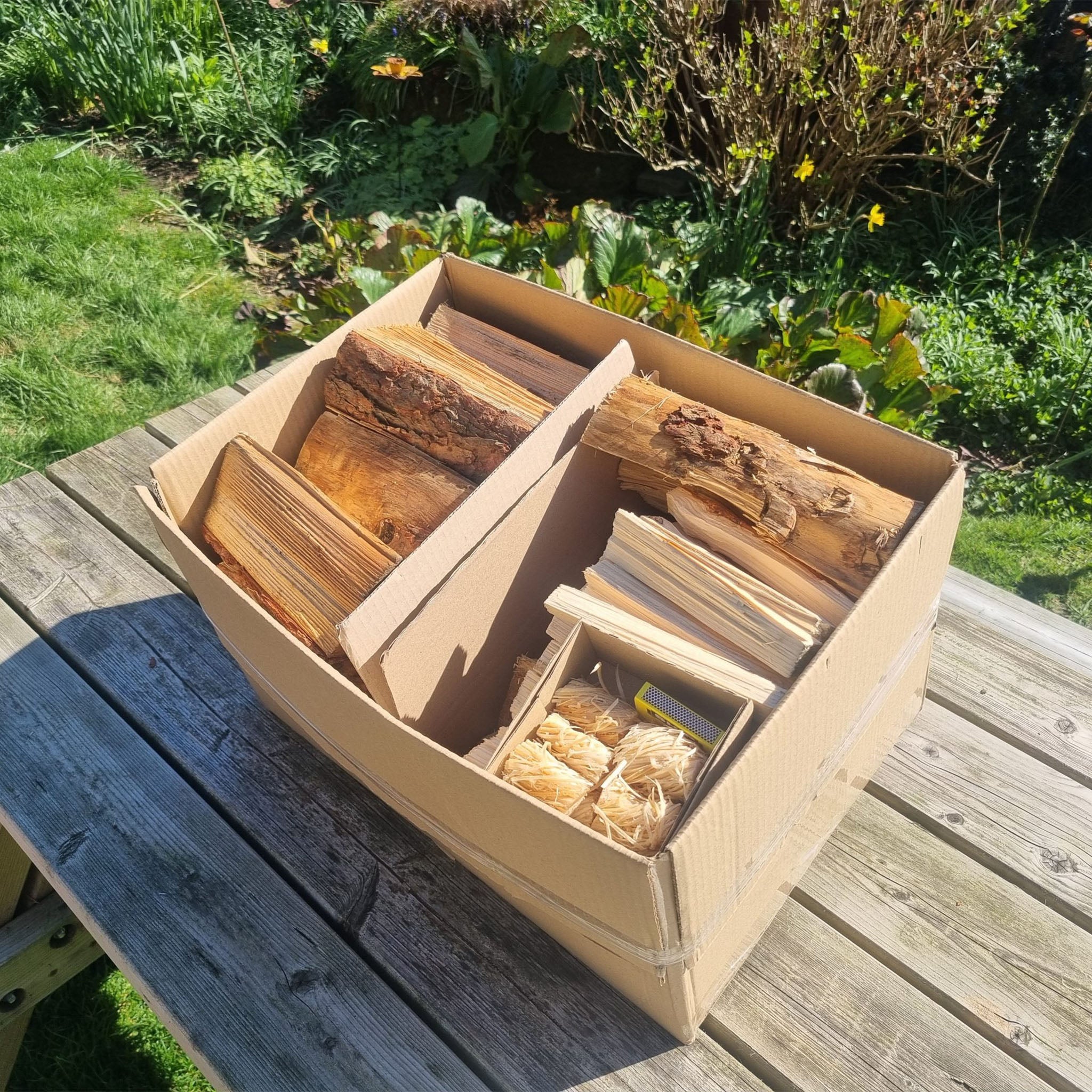 Wooden box with firewood on a wooden table outdoors